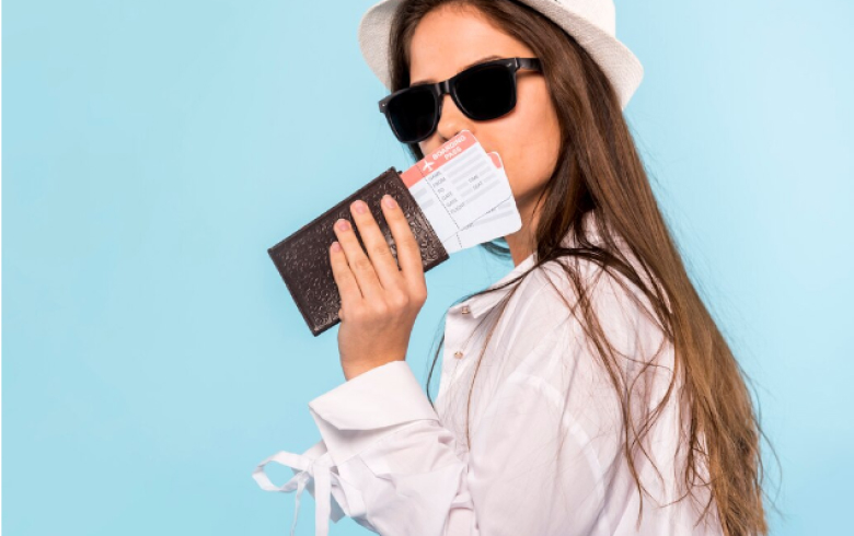 The girl holds a passport and tickets to Indonesia in her hands